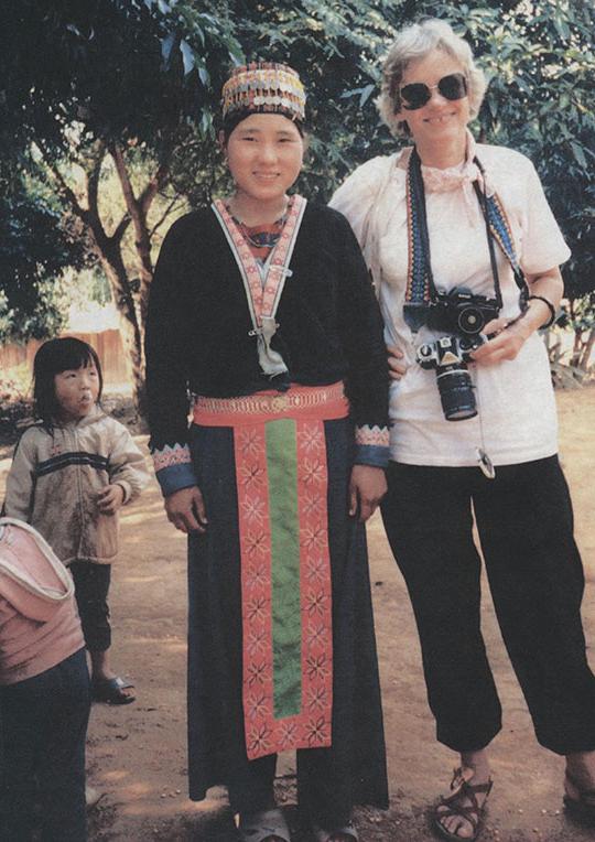 一名手持相机的妇女站在另一名妇女和一个孩子旁边